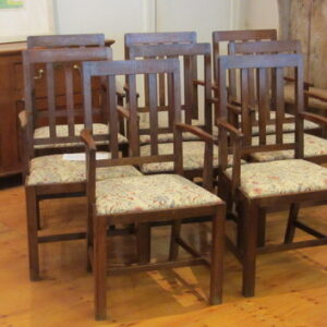 An exceptional and rare set of eight early 20th Century English oak arm chairs