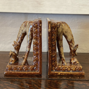 A fine pair of decorative European ceramic bookends of a giraffe loving her calf.