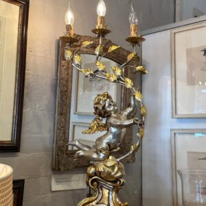 A highly decorative contemporary pair of gold and silver gilt, Italianate baroque style Florentine winged cherub and foliate decorated three light candelabra.