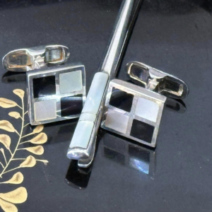 A pair of mother of pearl and onyx cufflinks and matching tie bar.